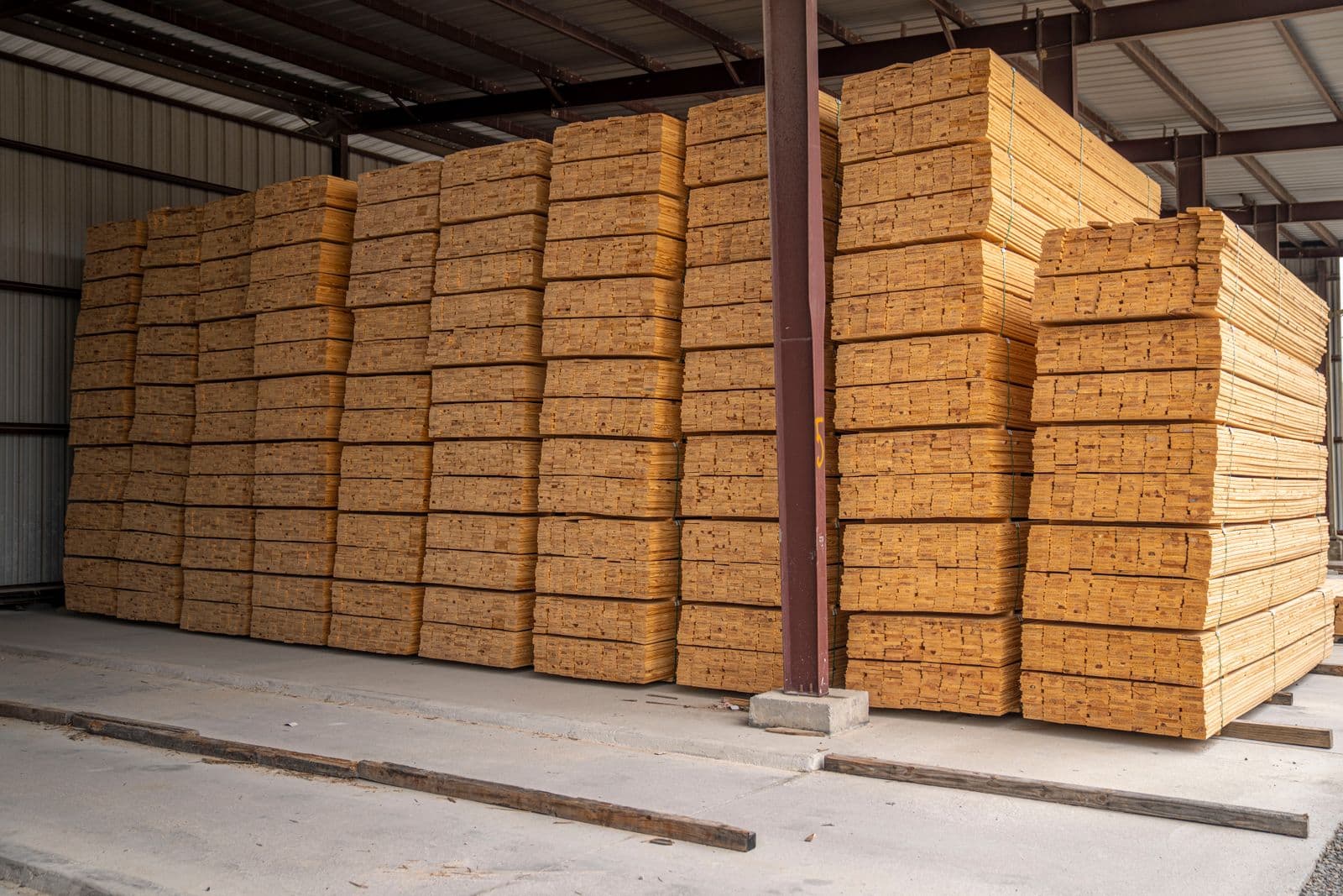Piles de planches sciées stockées sous hangar
